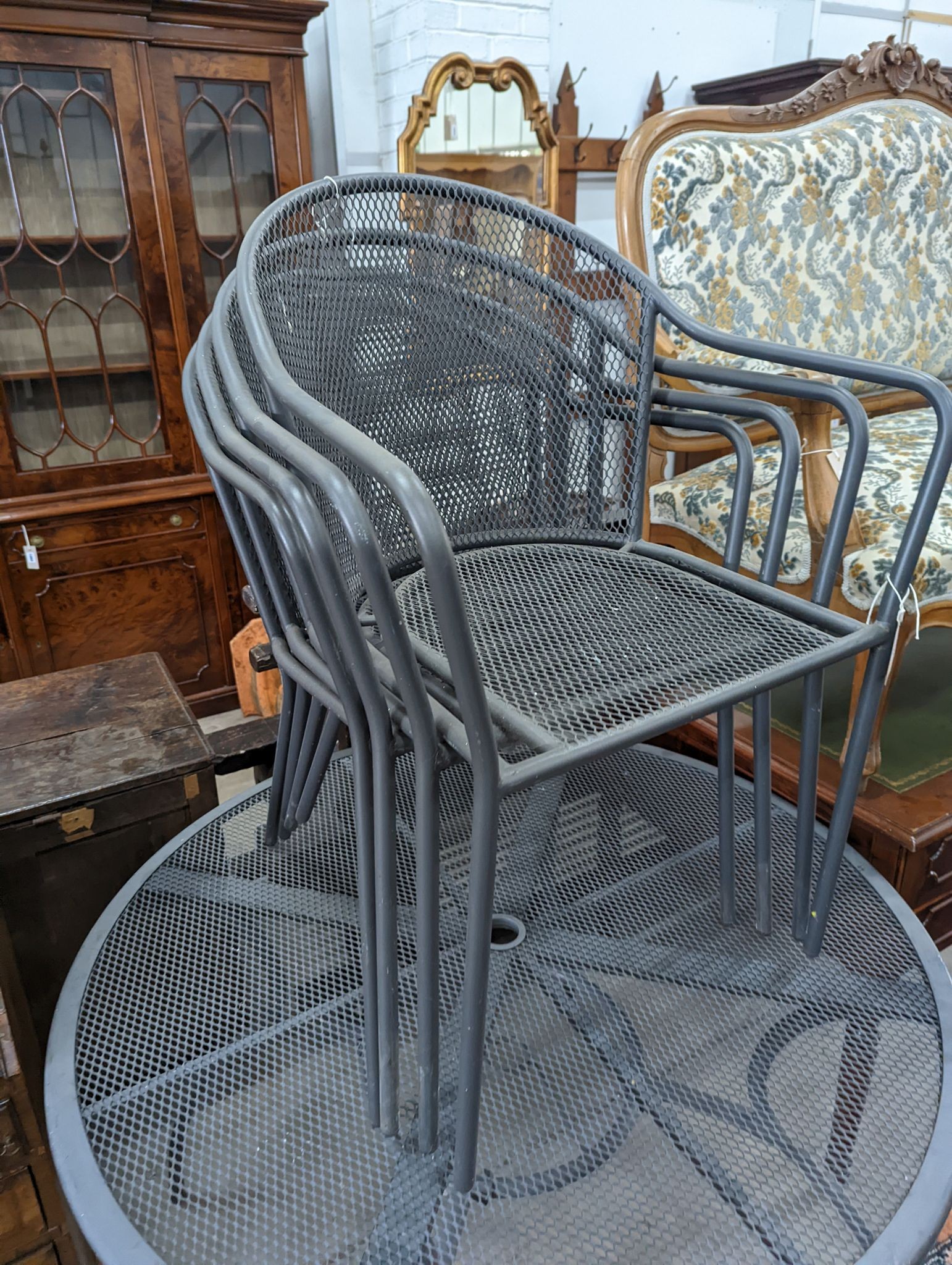 A painted and aluminium wirework circular garden table, diameter 110cm and four chairs
